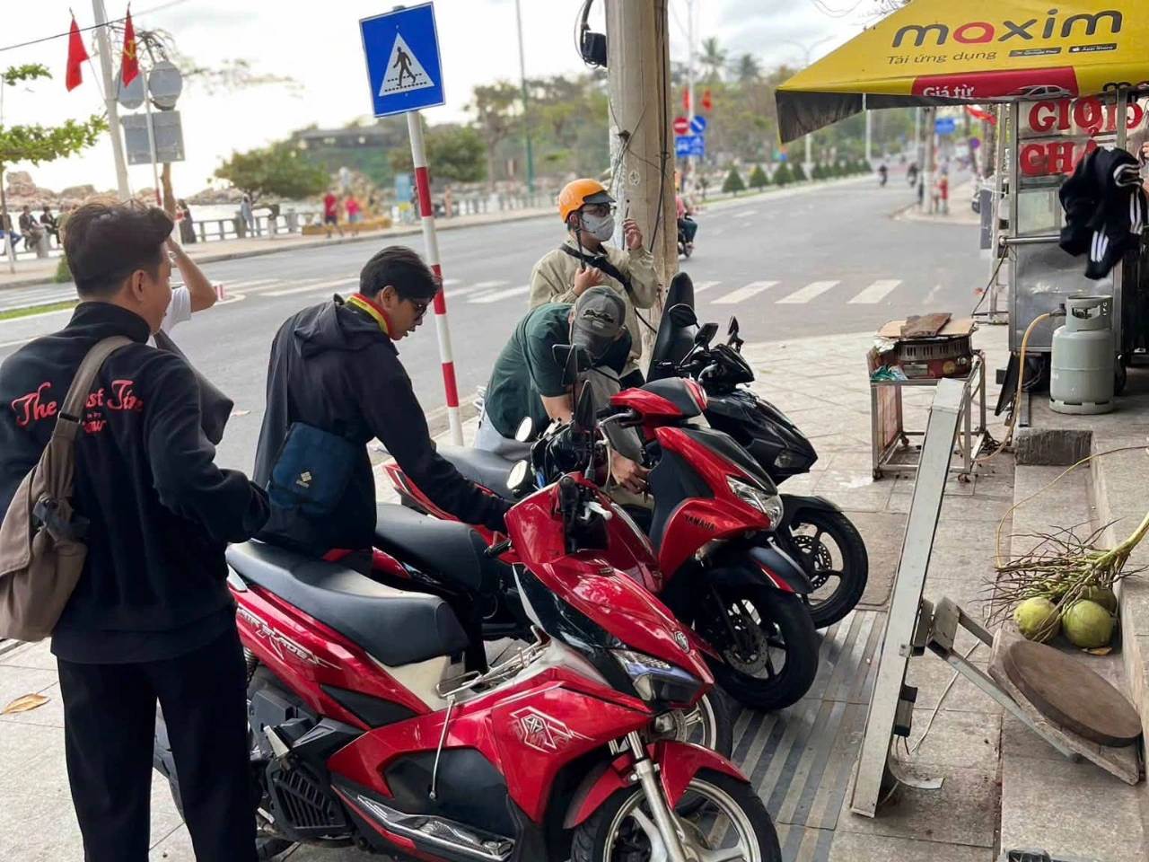 Du khách lái xe máy trên cung đường ven biển Nha Trang với nắng và biển xanh
